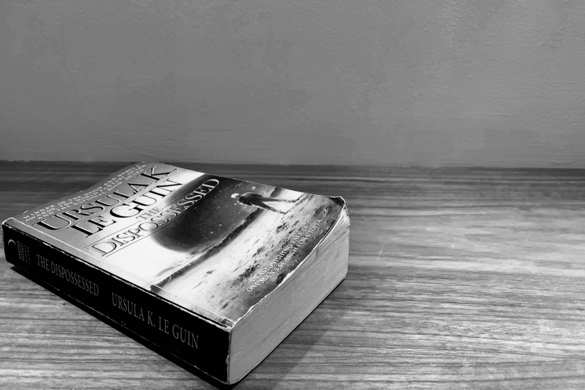 livre sur un décor lunaire, the dispossessed, les dépossédés, Ursula K. Le Guin, Harper Voyager, science-fiction, littératures de l’imaginaire, féminisme, collectivité, individualisme, le fil rouge, le fil rouge lit, quête existentielle, philosophie